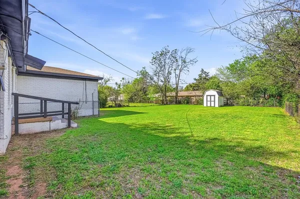 a view of a house with a yard potted plants and large tree