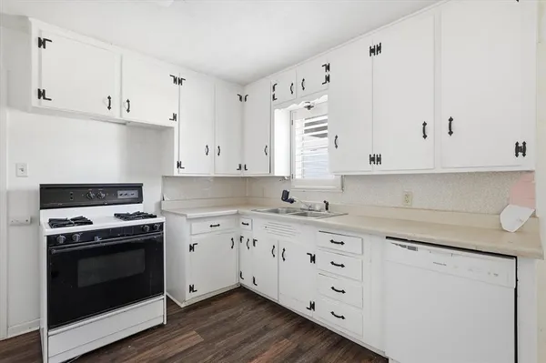 a kitchen with white cabinets and white appliances