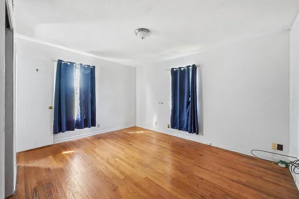 a view of an empty room with wooden floor