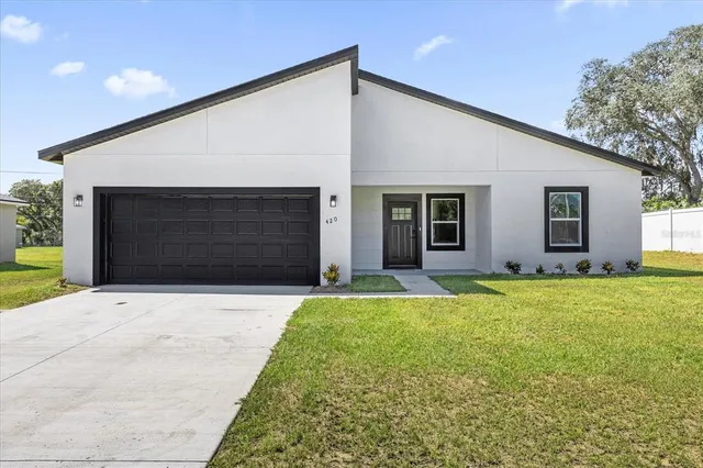 a front view of a house with a yard and garage
