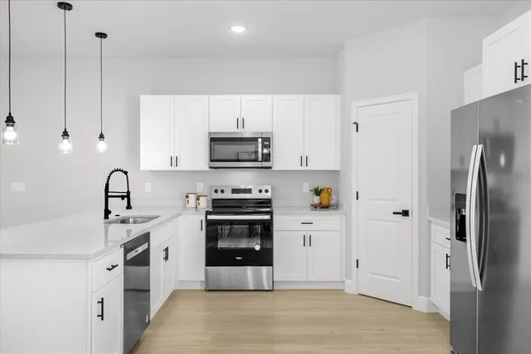 a kitchen with stainless steel appliances a stove a sink and a refrigerator