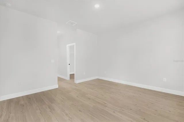 an empty room with wooden floor and white walls