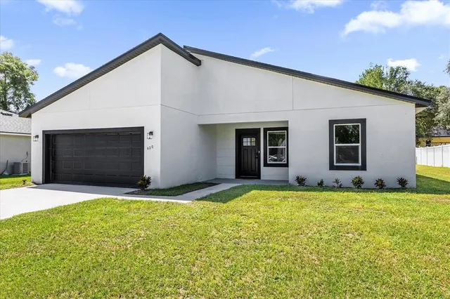 a view of a house with a yard and garage