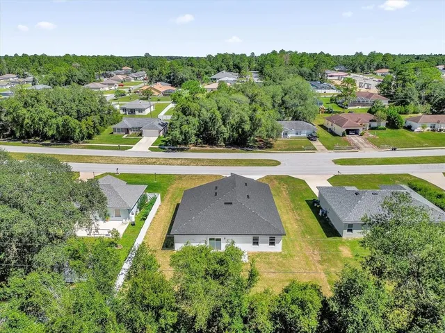 an aerial view of residential houses with outdoor space and swimming pool