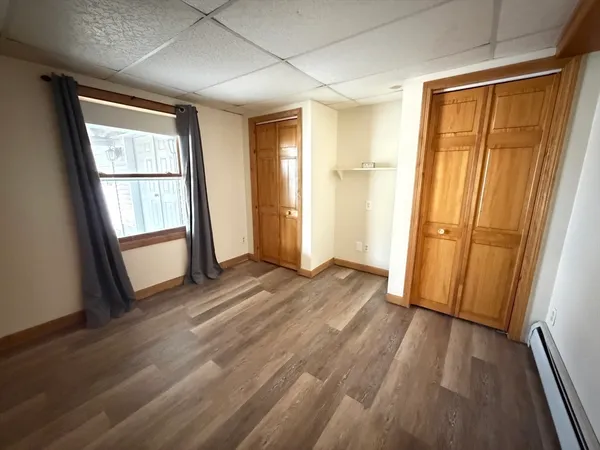 a view of a bedroom with wooden floor and a window