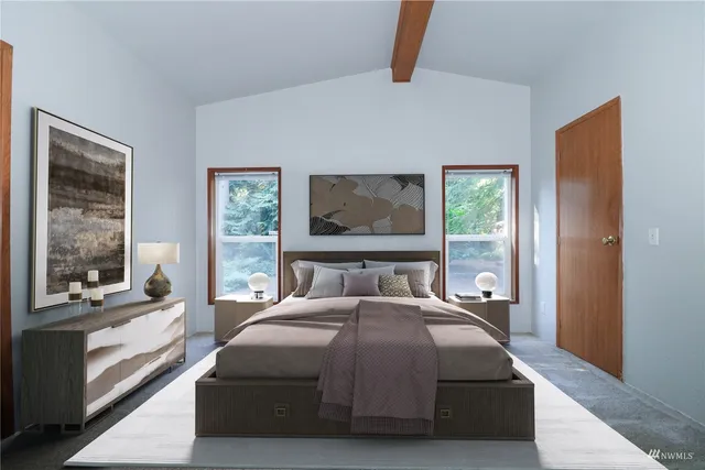 a bedroom with a bed and a large window