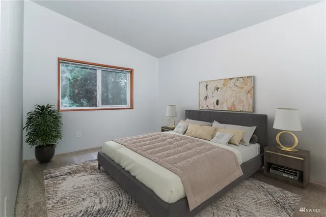 a bedroom with a bed and a painting on the wall