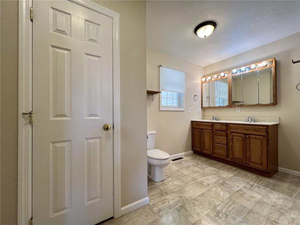 43 Maple Street Uniontown, PA 15401 - Photo 17 of 26 a bathroom with a granite countertop toilet sink and mirror