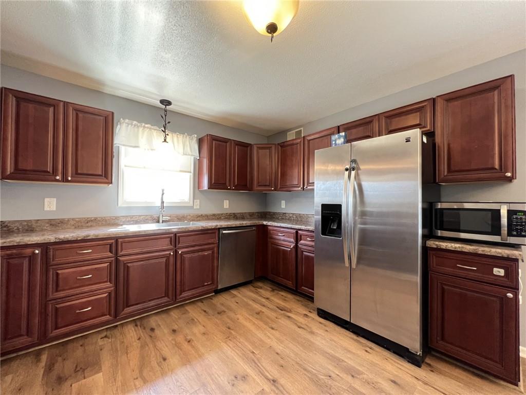 43 Maple Street Uniontown, PA 15401 - Photo 8 of 26 a kitchen with stainless steel appliances granite countertop a refrigerator a sink dishwasher a stove with wooden cabinets and floor