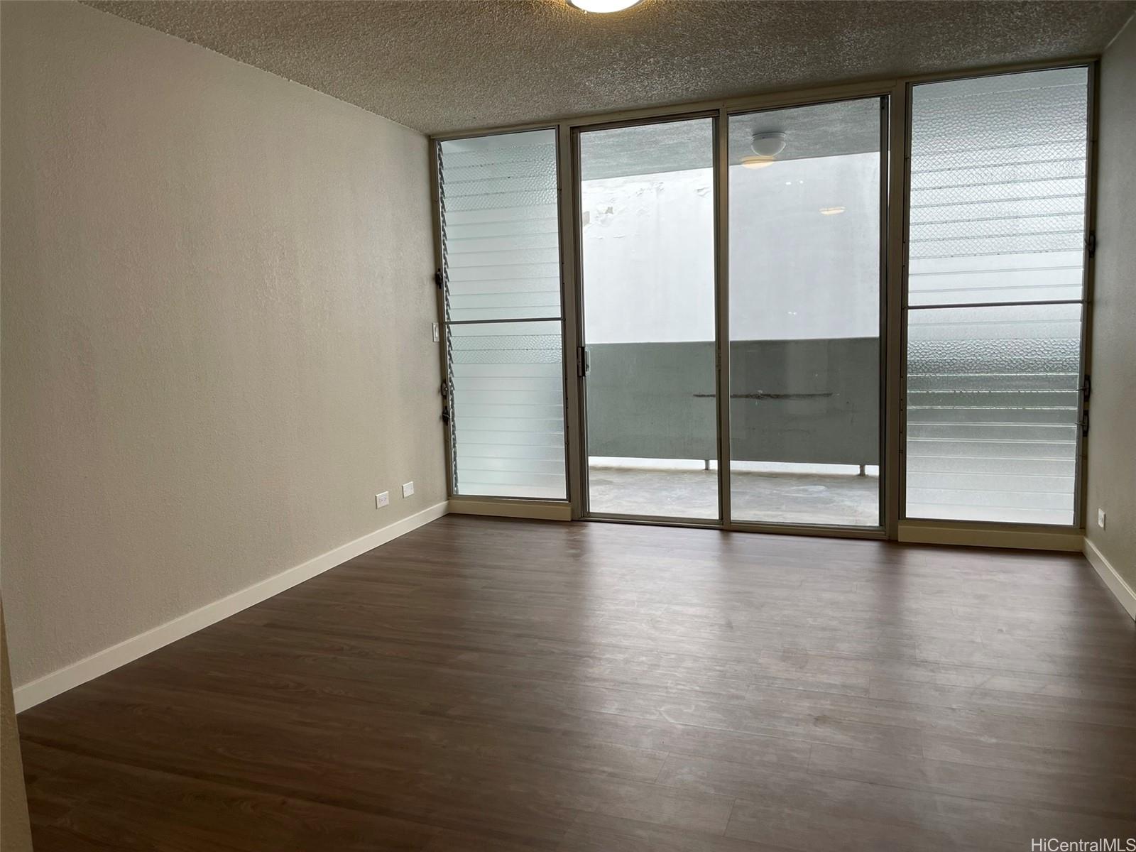 620 Sheridan Street, Unit 404 Honolulu, HI 96814 - Photo 4 of 10 a view of an empty room with wooden floor and a window