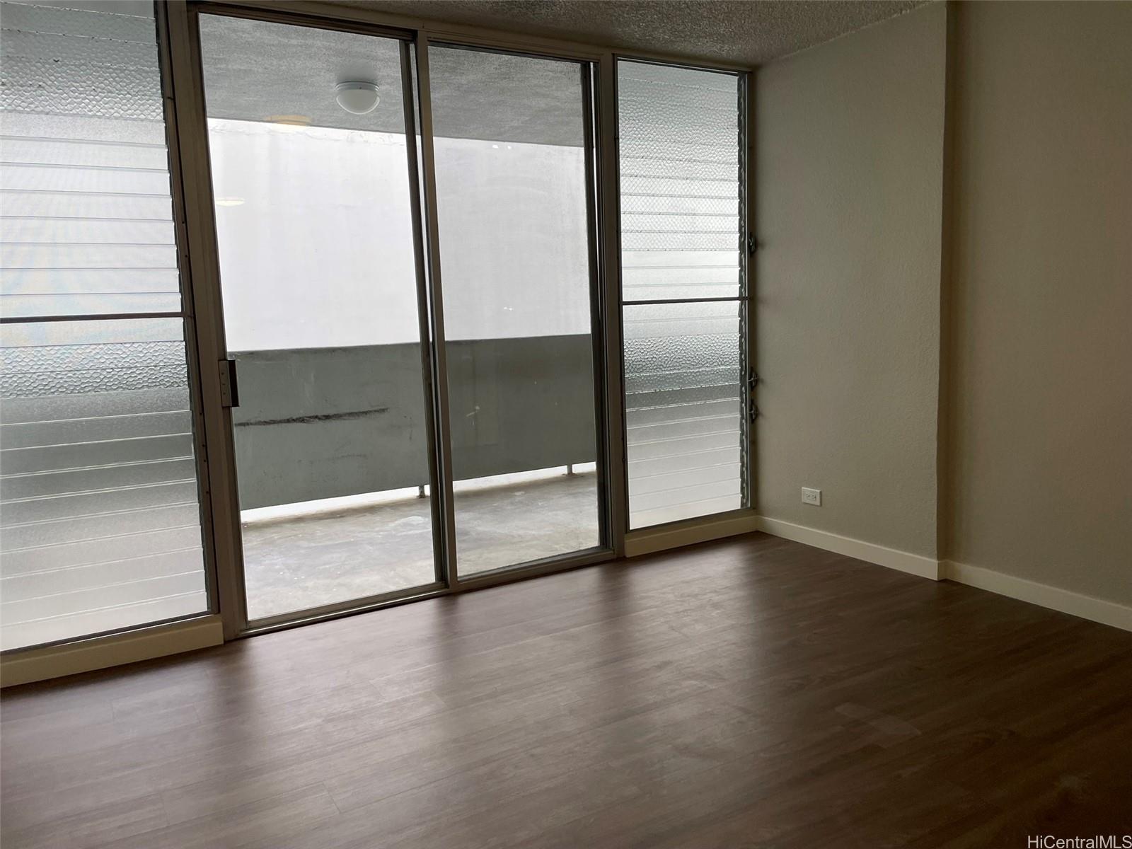 620 Sheridan Street, Unit 404 Honolulu, HI 96814 - Photo 5 of 10 a view of an empty room with wooden floor and a window