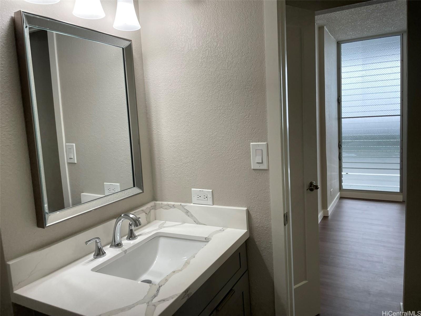 620 Sheridan Street, Unit 404 Honolulu, HI 96814 - Photo 8 of 10 a bathroom with a sink and a mirror