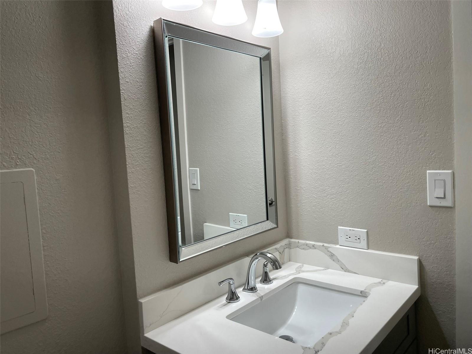 620 Sheridan Street, Unit 404 Honolulu, HI 96814 - Photo 9 of 10 a bathroom with a sink and a mirror