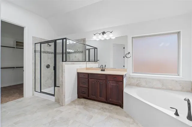a spacious bathroom with a tub sink and mirror