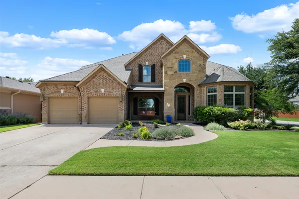 a front view of a house with a garden and yard
