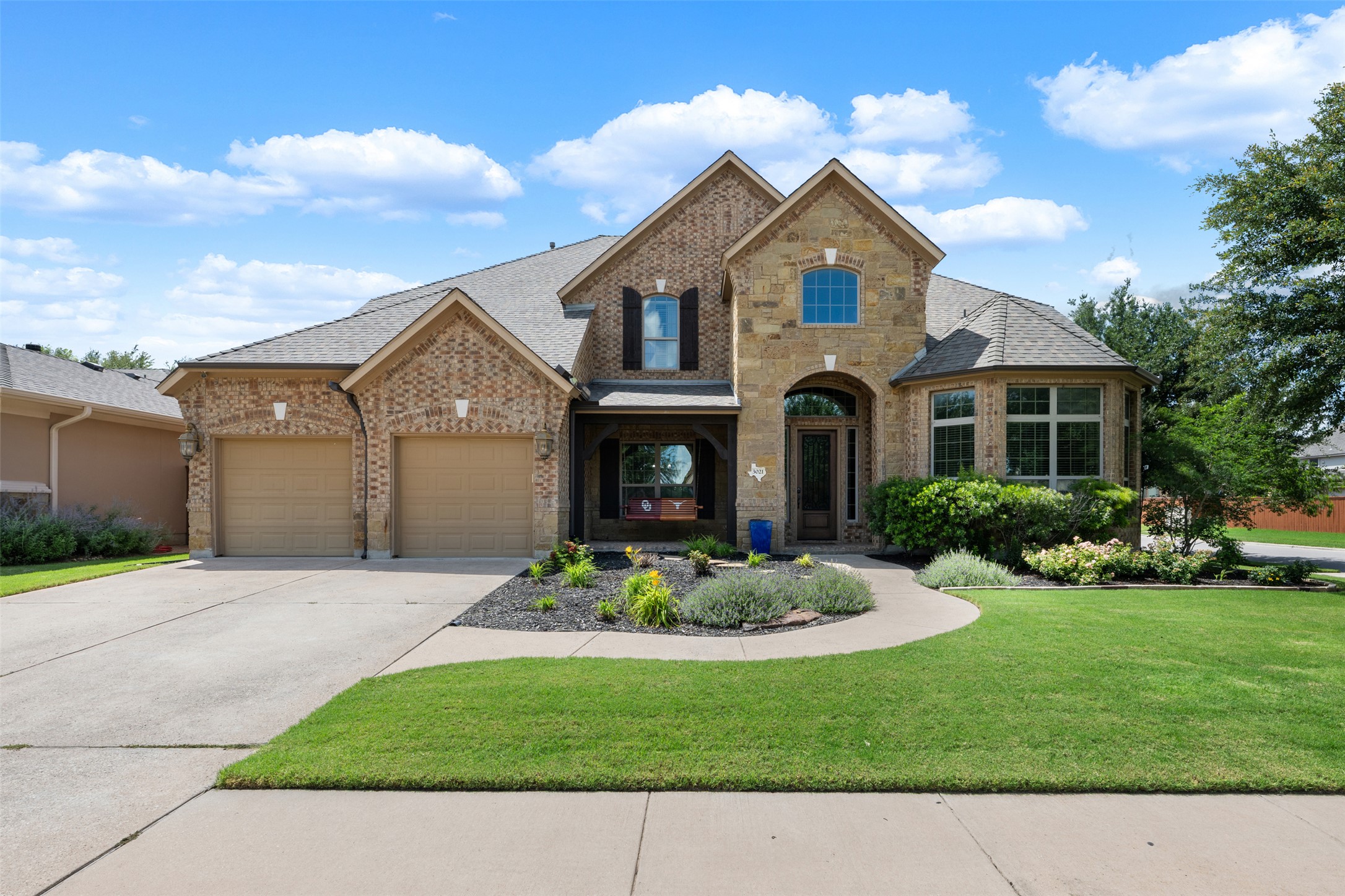 a front view of a house with a garden and yard