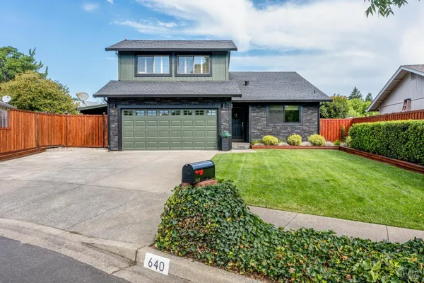 a front view of a house with a yard and garage