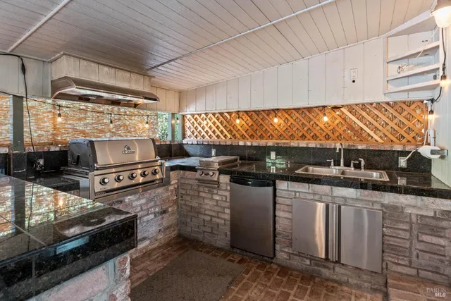 a kitchen with stainless steel appliances kitchen island granite countertop a stove a sink and white cabinets