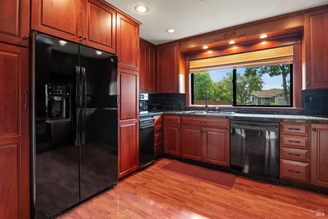 a kitchen with stainless steel appliances granite countertop a stove a sink and a refrigerator