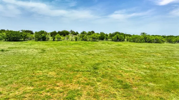 a view of a green field with wooden fence