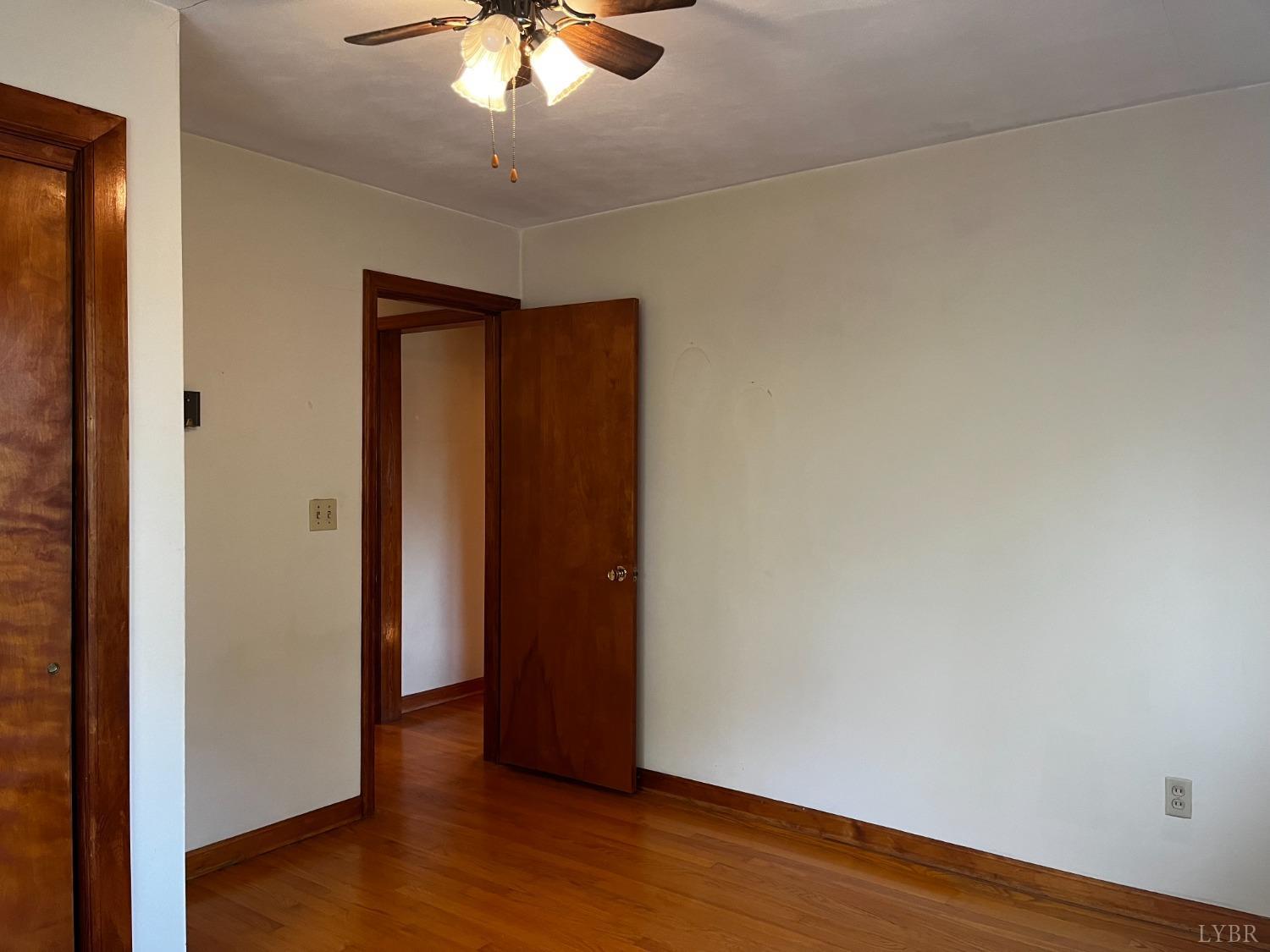1089 Howell Ridge Lane Vinton, VA 24179 - Photo 14 of 39 an empty room with wooden floor and chandelier fan