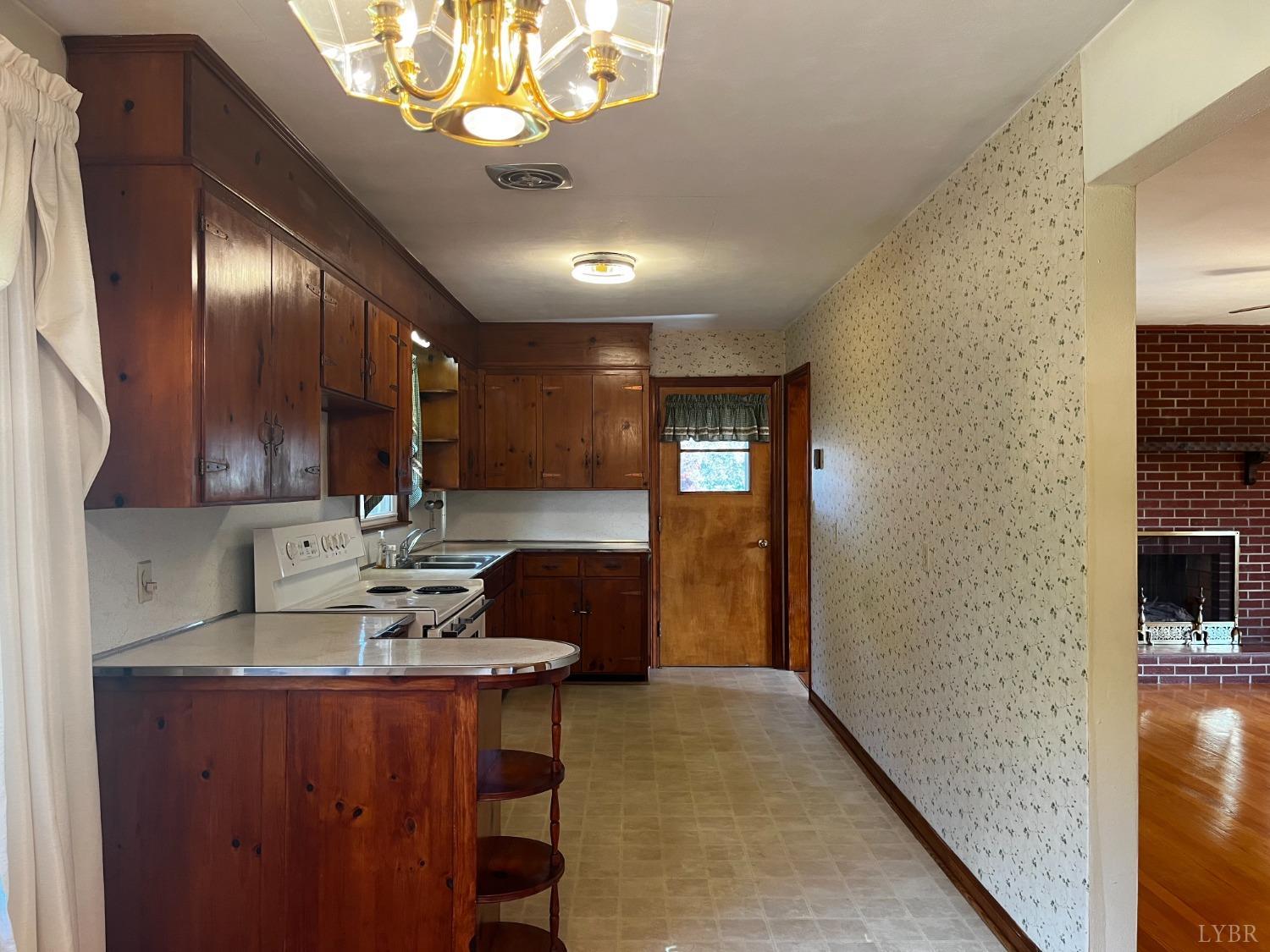 1089 Howell Ridge Lane Vinton, VA 24179 - Photo 6 of 39 a kitchen with stainless steel appliances kitchen island granite countertop a refrigerator a sink dishwasher a dining table and chairs with wooden floor