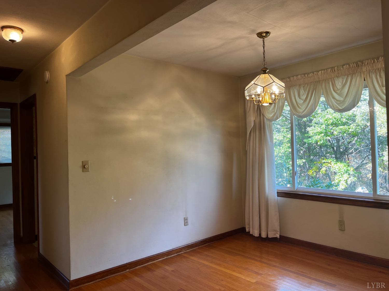 1089 Howell Ridge Lane Vinton, VA 24179 - Photo 10 of 39 a view of empty room with window wooden floor and chandelier