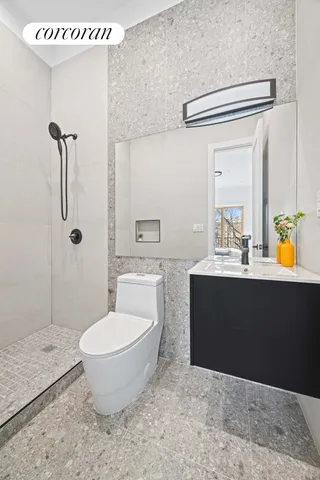a bathroom with a sink a toilet and shower