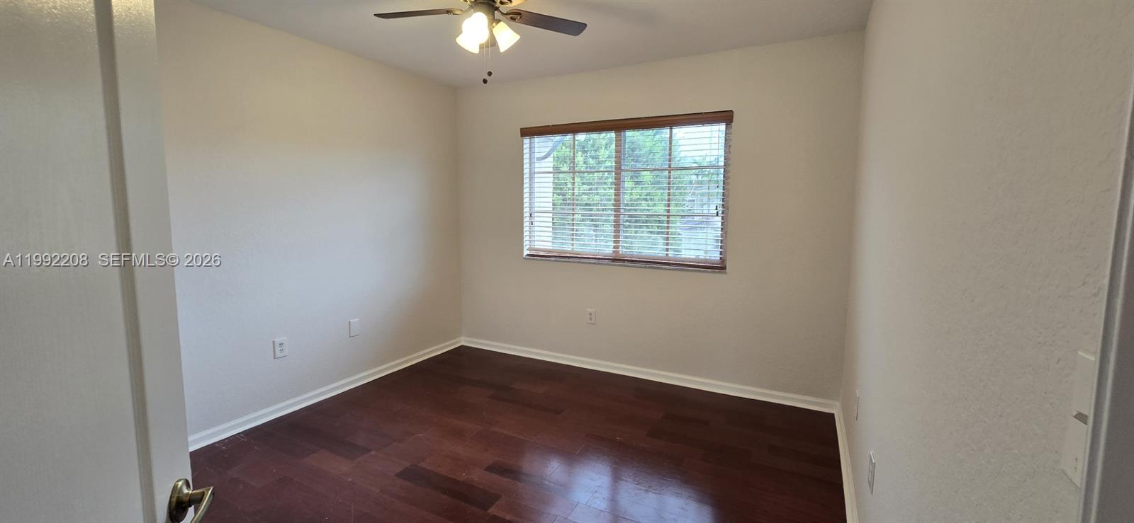 14067 Southwest 272nd Street Homestead, FL 33032 - Photo 12 of 36 an empty room with wooden floor and windows