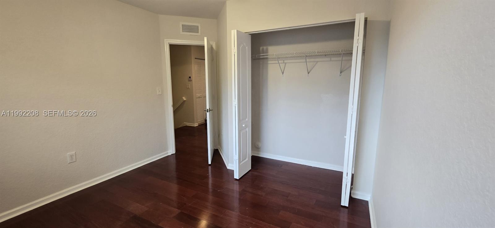 14067 Southwest 272nd Street Homestead, FL 33032 - Photo 13 of 36 an empty room with wooden floor & closet and a bathroom