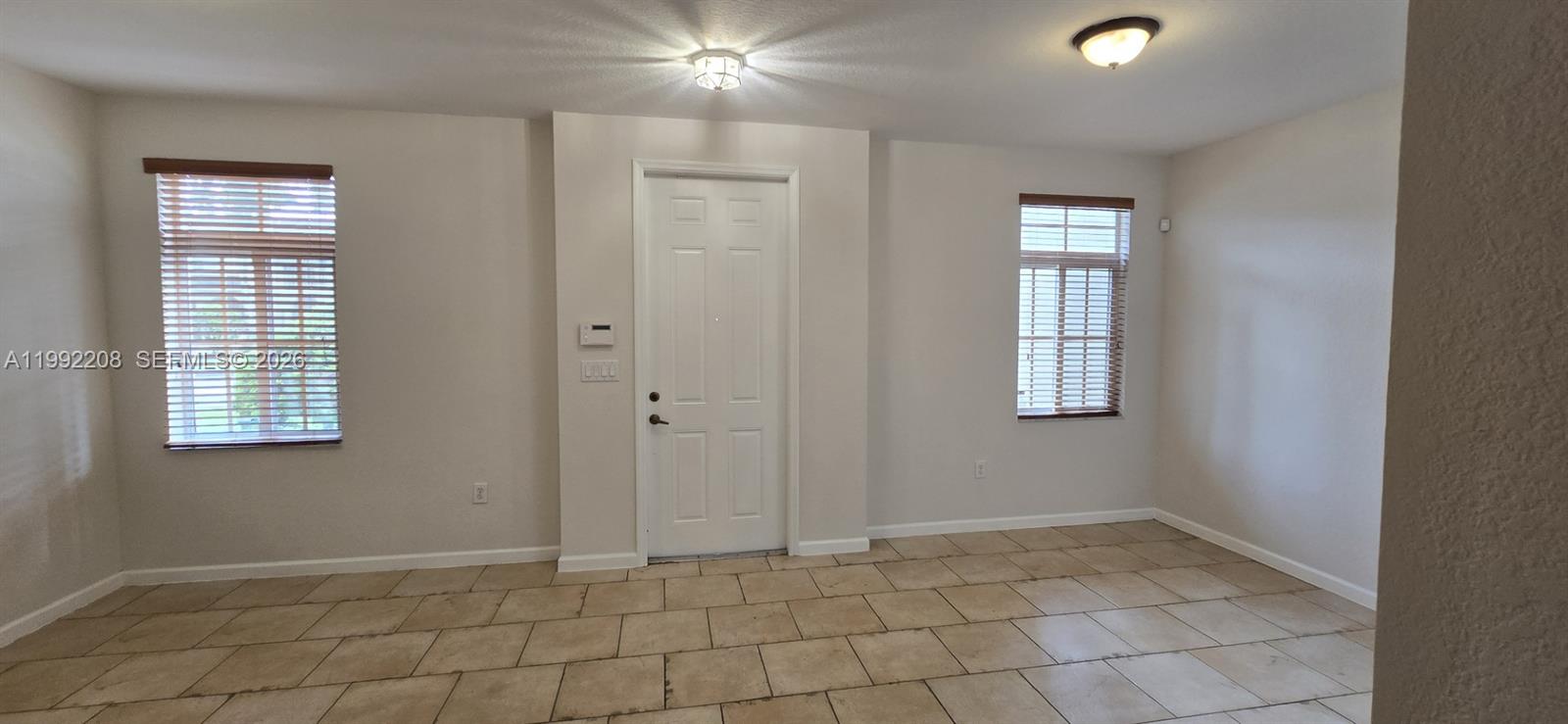 14067 Southwest 272nd Street Homestead, FL 33032 - Photo 6 of 36 an empty room with windows and closet