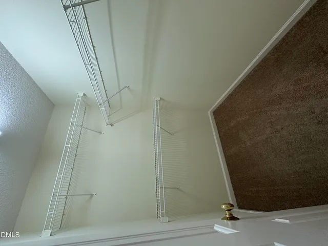 en empty room with windows and chandelier fan