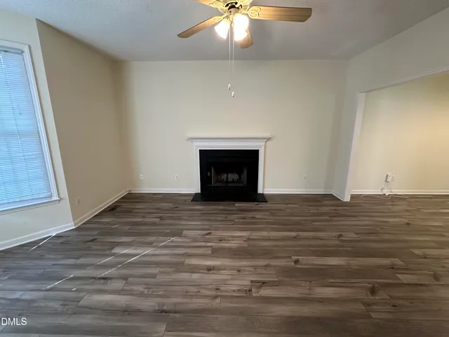 a view of an empty room with a fireplace and a window