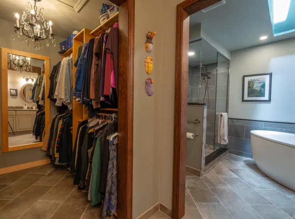 a view of walk in closet with clothes and shoes