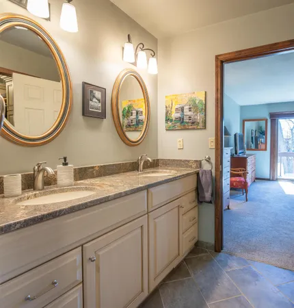 a bathroom with a granite countertop double vanity sink and a mirror