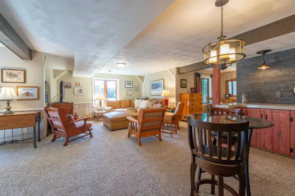 a dining room with furniture a chandelier and window