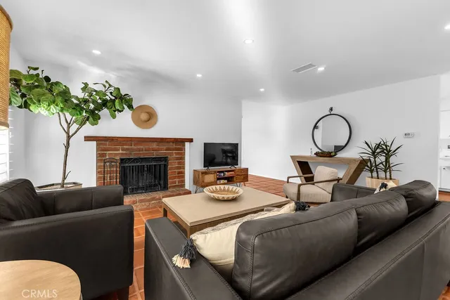 a living room with furniture a fireplace and a potted plant