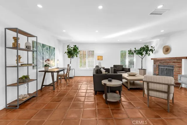 a living room with patio furniture and a fireplace