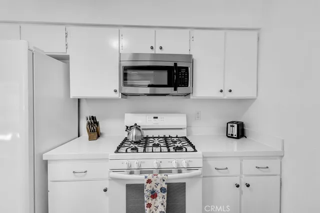 a kitchen with appliances a sink and cabinets