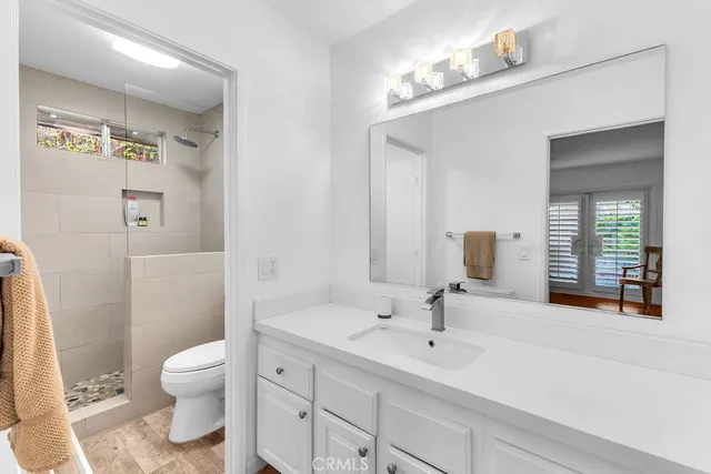 a bathroom with a sink a toilet and shower