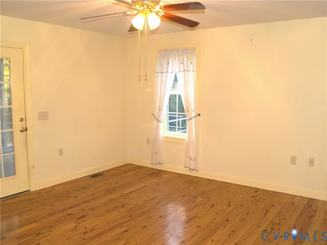 a view of an empty room with closet and a window