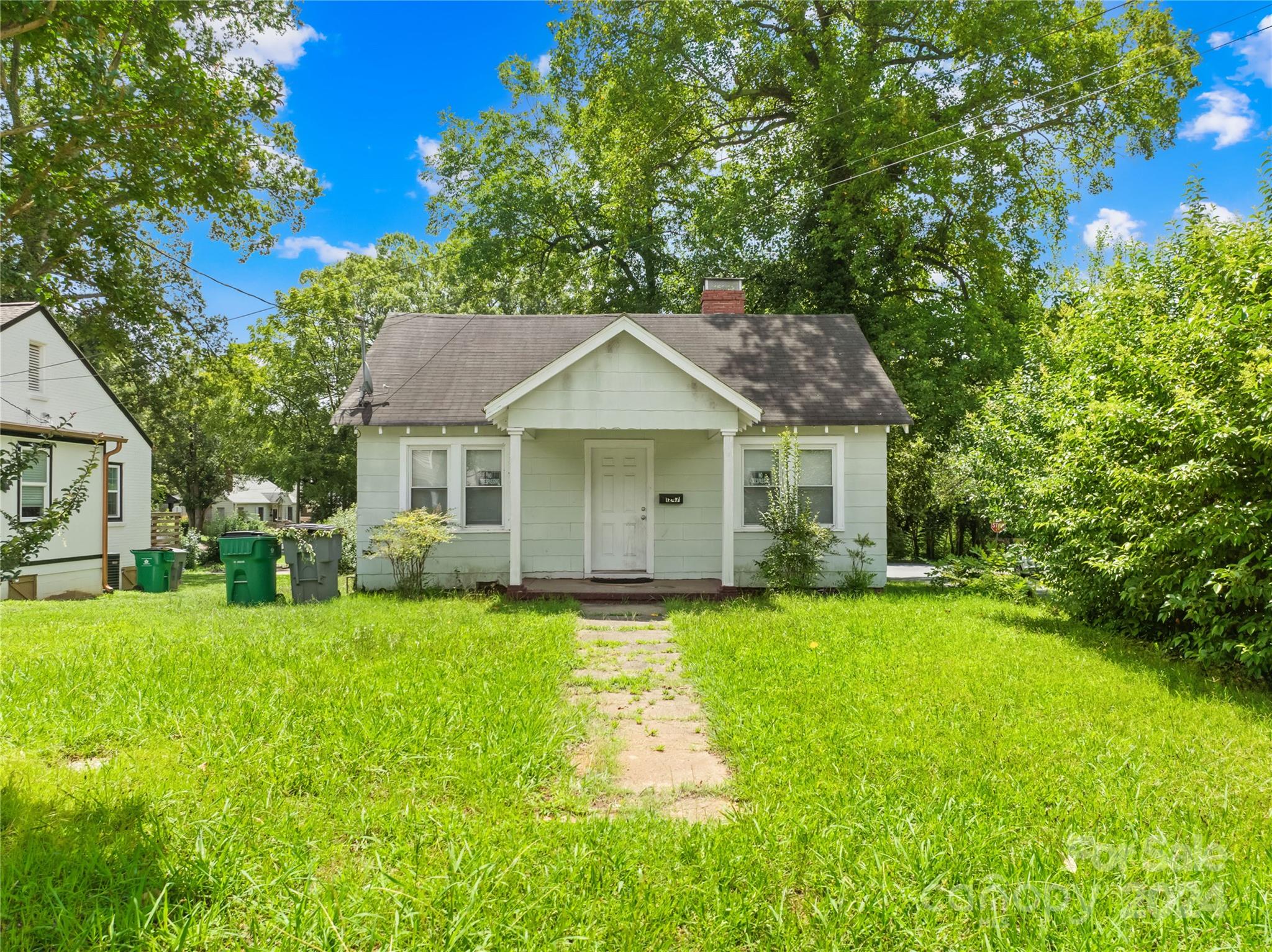 1247 Effingham Road Charlotte, NC 28208 - Photo 5 of 19 a front view of a house with a yard and trees