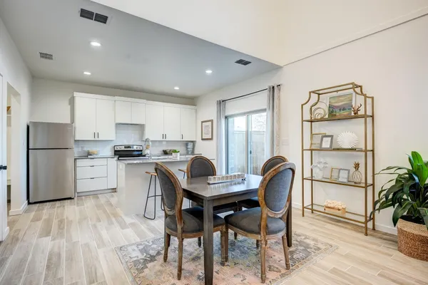 a kitchen with stainless steel appliances granite countertop a stove a sink dishwasher and a refrigerator with wooden floor