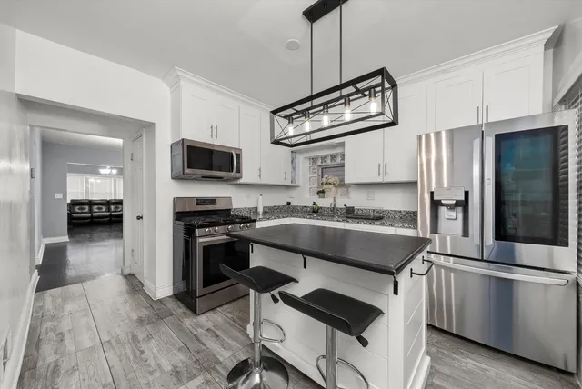 a kitchen with stainless steel appliances granite countertop a stove refrigerator and microwave