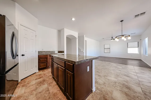 a kitchen with stainless steel appliances granite countertop a refrigerator and a stove