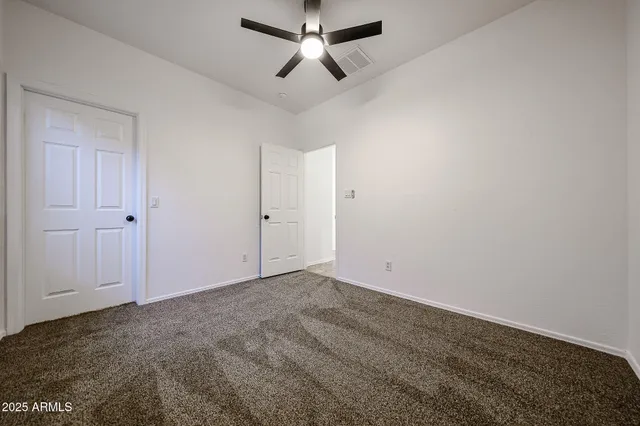 an empty room with chandelier fan