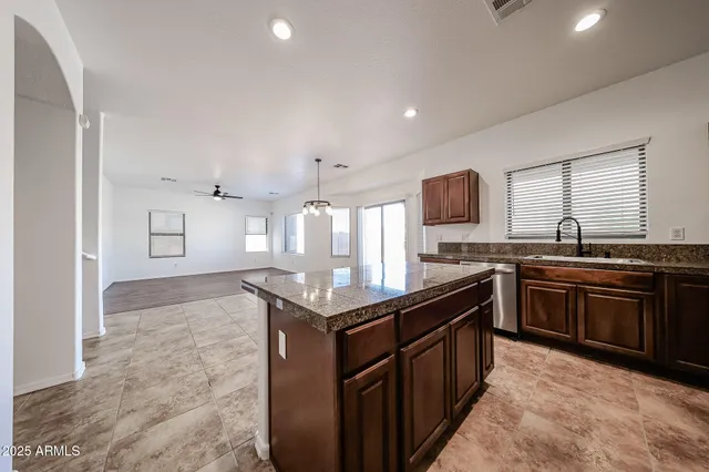 a kitchen with stainless steel appliances granite countertop a stove top oven a sink a counter space and cabinets