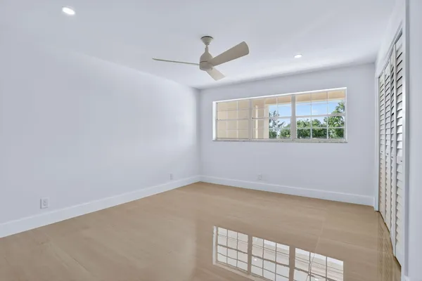 wooden floor in an empty room with a ceiling fan