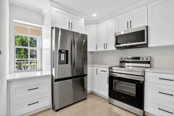 a kitchen with stainless steel appliances white cabinets and a stove