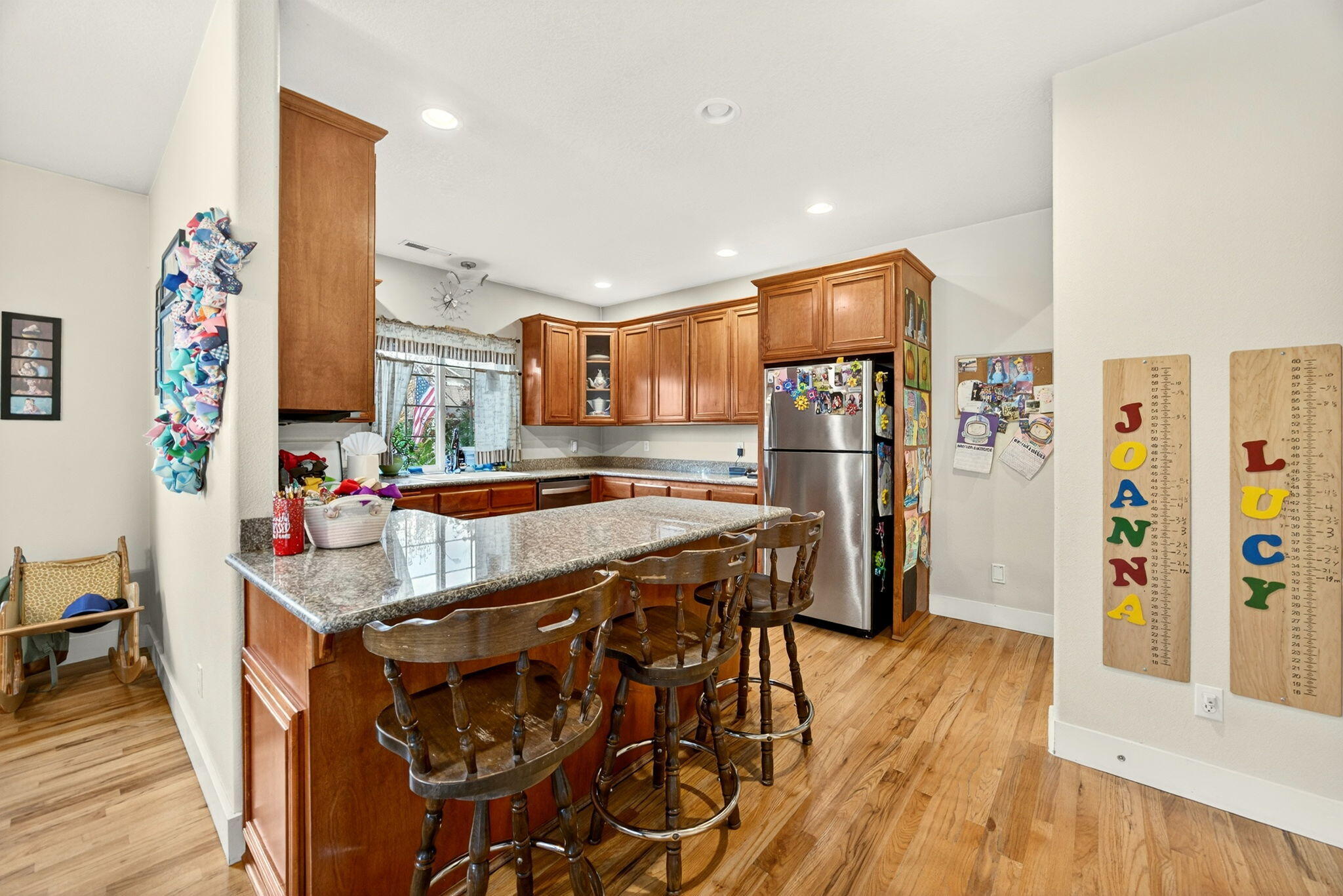 16 Portabello Way Eagle Point, OR 97524 - Photo 21 of 43 a kitchen with stainless steel appliances granite countertop a refrigerator a sink dishwasher a stove and a dining table with wooden floor